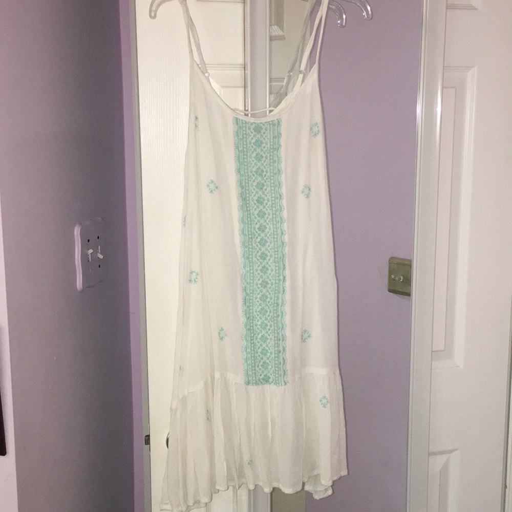 White dress with ruffle and teal/green design